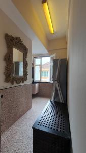 a bathroom with a mirror and a bench in a room at Betel Box Backpackers Hostel in Singapore