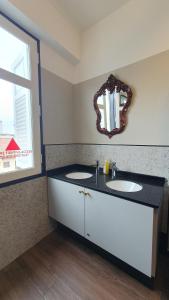 a bathroom with two sinks and a mirror on the wall at Betel Box Backpackers Hostel in Singapore