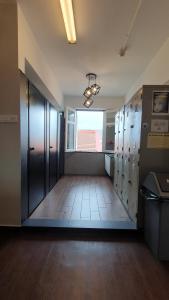 an empty locker room with a large door and a window at Betel Box Backpackers Hostel in Singapore