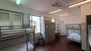 a dorm room with two bunk beds and a window at Betel Box Backpackers Hostel in Singapore
