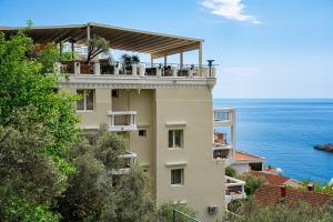 a building with a balcony overlooking the ocean at Hotel Adrović in Sveti Stefan