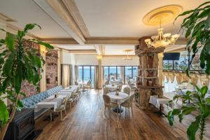 a restaurant with tables and chairs in a room at Hotel Adrović in Sveti Stefan