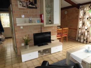 TV a/nebo společenská místnost v ubytování Ferienbungalow mit Terrasse in einem kleinen Ferienpark mit See