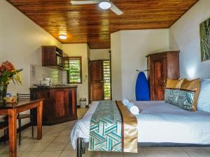 una camera con due letti e un tavolo e una cucina di Poppy's on the Lagoon a Port Vila