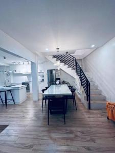 a dining room with a table and a staircase at White Villa in General Santos