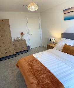 a bedroom with a large bed and a wooden cabinet at 3 Bedroom Apartment in Preston - Stunning City View in Preston