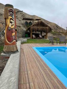 a resort with a statue next to a swimming pool at Cabaña de Campo Huaral, hermosas vistas Piscina in Huaral