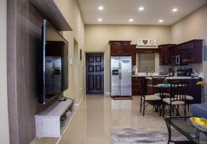 a kitchen with stainless steel appliances and a living room at Tropical Bliss Haven in Kingston