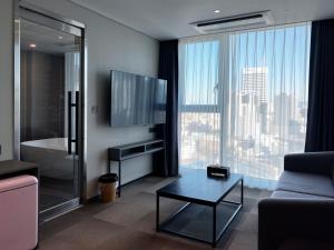 a living room with a tv and a couch and a table at Hotel U5 in Seoul