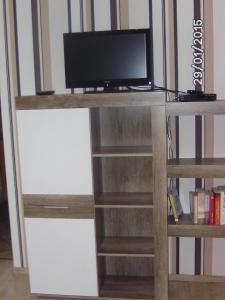 a tv sitting on top of a wooden book shelf at Appartement in Hilders mit Eigenem Balkon in Hilders