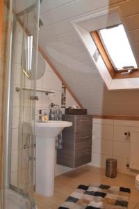 a bathroom with a sink and a shower with a skylight at Appartement in Hilders mit Eigenem Balkon in Hilders +14 photos