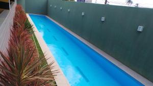 una gran piscina azul junto a un edificio en Emilio Hinko 3 Quartos apto1502 en Fortaleza