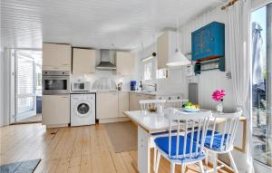 a kitchen with white cabinets and a table and chairs at Holiday Home Sneppevej Rødby Denm in Kramnitse +19 photos