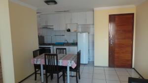 cocina con mesa, sillas y nevera en Emilio Hinko 3 Quartos apto1502, en Fortaleza