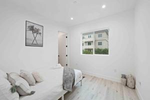 Una habitación blanca con una cama y una ventana. en Prime Location 3BD 3BA Luxury Living in LA, en Los Ángeles