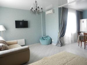 a living room with a couch and a tv on the wall at Apartment na Revolutsii in Voronezh