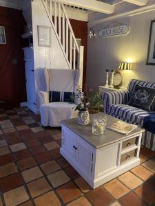 a living room with a couch and a table at Modernisiertes und hell eingerichtetes Ferienhaus mit eigenem Garten ideal für Familien in Krummhörn