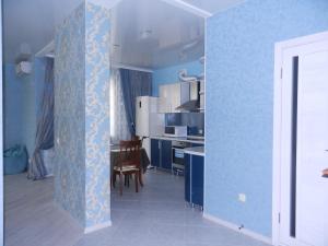 a kitchen with blue walls and a dining room at Apartment na Revolutsii in Voronezh