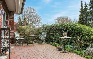een stenen patio met 2 stoelen en een tafel bij Cozy Apartment In Bad Zwischenahn in Bad Zwischenahn