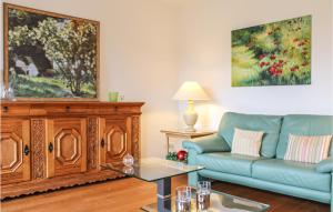 een woonkamer met een bank en een tv bij Cozy Apartment In Bad Zwischenahn in Bad Zwischenahn