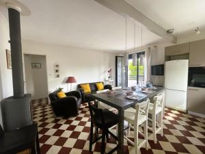 eine Küche und ein Wohnzimmer mit Tisch und Herd in der Unterkunft Maison de charme rénovée près du port ostréicole, idéale pour vacances à pied ou à vélo - FR-1-420-147 in La Teste-de-Buch