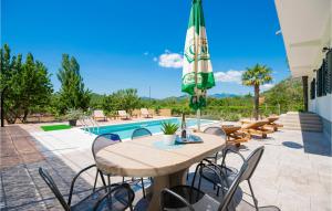 a patio with a table and chairs and an umbrella at Three-Bedroom Apartment In Kresevo in Kreševo