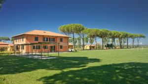 una casa con un grande campo di fronte ad essa di La Fattoria di Tirrenia a Tirrenia