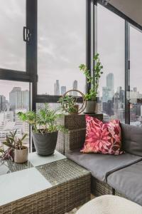 a balcony with a couch and potted plants at VAQUAY Ambrosia In Southbank in Melbourne
