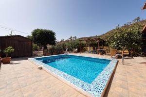 ein Schwimmbad in einem Hof neben einem Haus in der Unterkunft Liebevoll eingerichtetes und geräumiges Ferienhaus mit großem Garten und einem privaten Pool in San Bartolomé de Tirajana