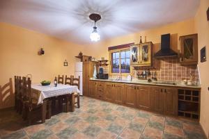 eine Küche mit Tisch und Kühlschrank in der Unterkunft Liebevoll eingerichtetes und geräumiges Ferienhaus mit großem Garten und einem privaten Pool in San Bartolomé de Tirajana