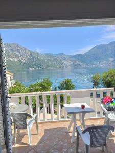 a balcony with a table and chairs and a view of the water at Amarillys in Donji Morinj
