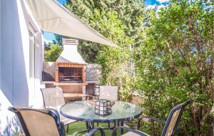 ペニスコラにある3 Bedroom Cozy Home In Peñiscolaのテーブルと椅子とグリルのあるパティオ