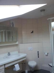 a white bathroom with a sink and a toilet at Gemütliche Ferienwohnung in Kuchelmiß mit Großem Garten in Kuchelmiß