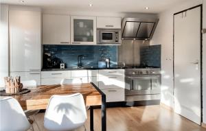 Stavenisseにある3 Bedroom Gorgeous Home In Stavenisseの白いキャビネットと木製のテーブルのあるキッチン