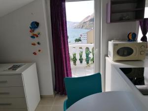 a kitchen with a window with a view of the ocean at STUDIO APARTMAN kat in Baška