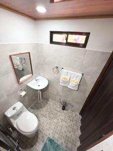a bathroom with a white toilet and a sink at Cabañas Hermanos Solano in San Francisco +29 photos