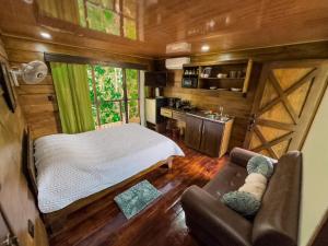 a bedroom in a tiny house with a bed and a couch at Cabañas Hermanos Solano in San Francisco