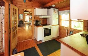 a kitchen with white appliances in a log cabin at 3 Bedroom Beautiful Home In Samsø in Onsbjerg