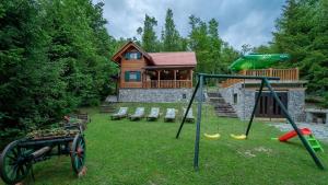 einen Hof mit Schaukeln und einem Blockhaus in der Unterkunft Ferienhaus für 7 Personen ca 80 qm in Lokve, Kvarner Bucht Gespanschaft Primorje-Gorski in Lokve