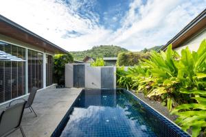 an outdoor swimming pool in the backyard of a house at Sunpao Pool Villa by HCR in Layan Beach