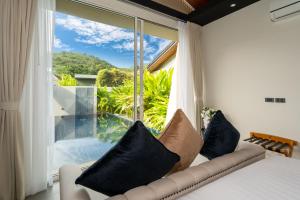 a room with a couch and a large window at Sunpao Pool Villa by HCR in Layan Beach +83 photos
