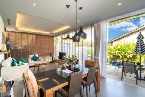 a dining room and living room with a dining table at Sunpao Pool Villa by HCR in Layan Beach
