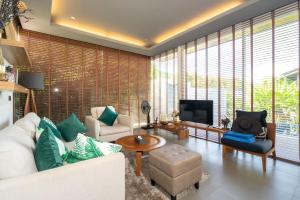 a living room with a couch and a tv at Sunpao Pool Villa by HCR in Layan Beach