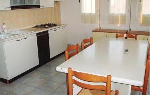 a kitchen with a white table and chairs in it at Agostina 3 in Rosolina Mare