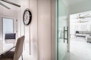 a dining room with a clock on a wall at Poolside Opulence Tennis and HotTub in Corpus Christi +42 photos