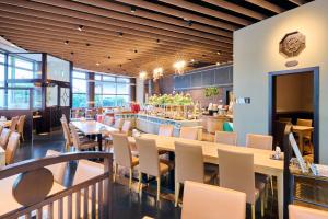 a restaurant with wooden ceilings and tables and chairs at Hotel Kumamoto Terrsa in Kumamoto