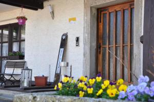 a sign in front of a door with flowers at Ferienhof Landhaus Guglhupf in Sankt Oswald