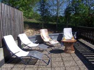 three chairs and a table on a patio at Ferienhof Landhaus Guglhupf in Sankt Oswald +12 photos
