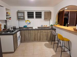 a kitchen with a counter and two stools at La Jandyra in Gros-Morne