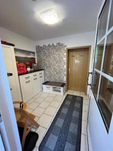 a kitchen with white cabinets and a stone wall at Neue Ferienwohnung in Warnstedt mit Garten, Grill und Terrasse in Thale